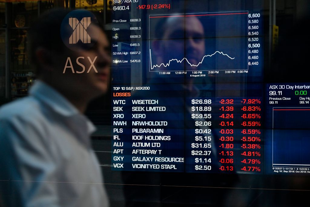People monitor stocks prices on an electronic screen at the Australian Stock Exchange in Sydney.