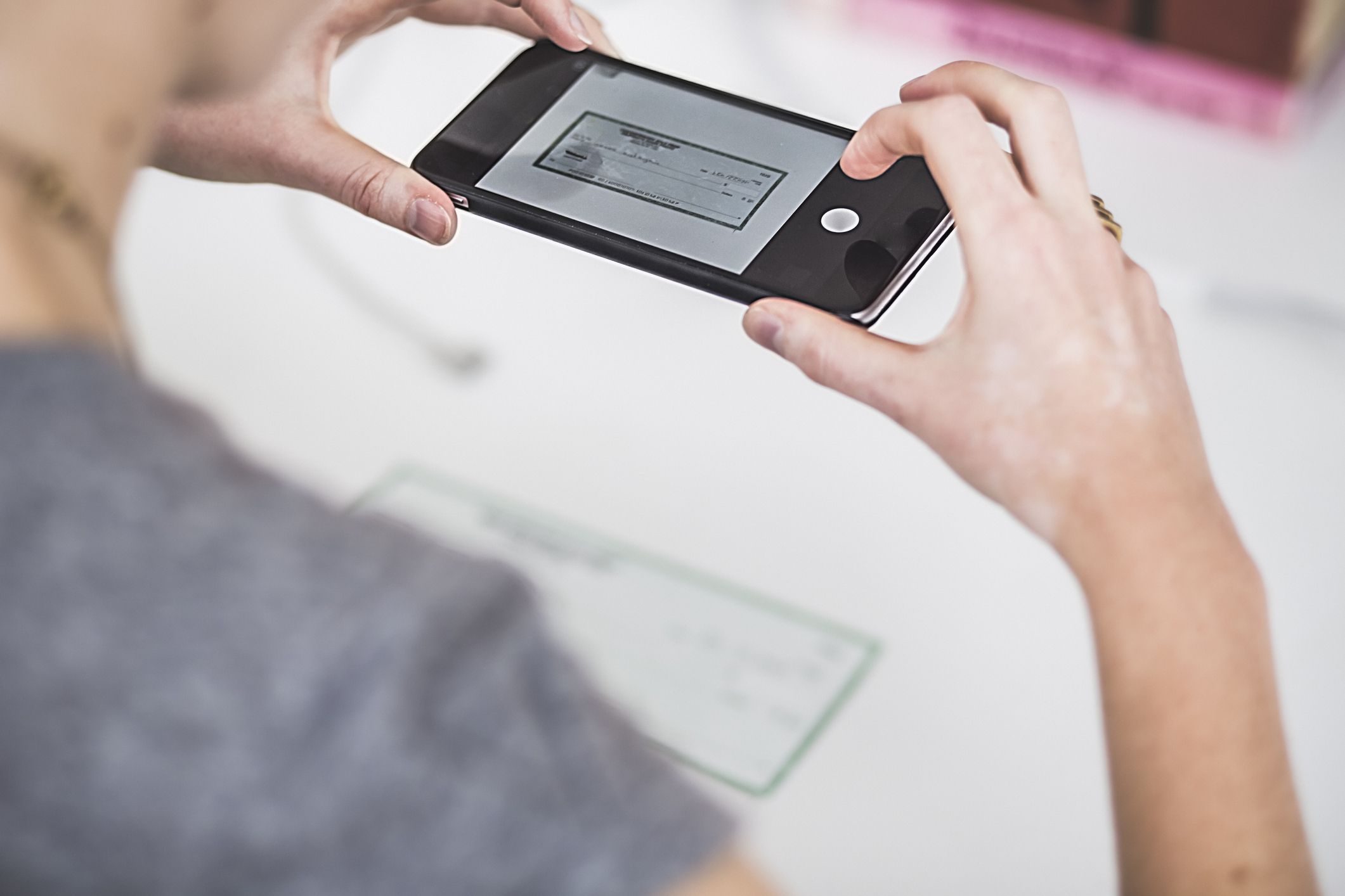 Cropped hands scanning a check with a smartphone