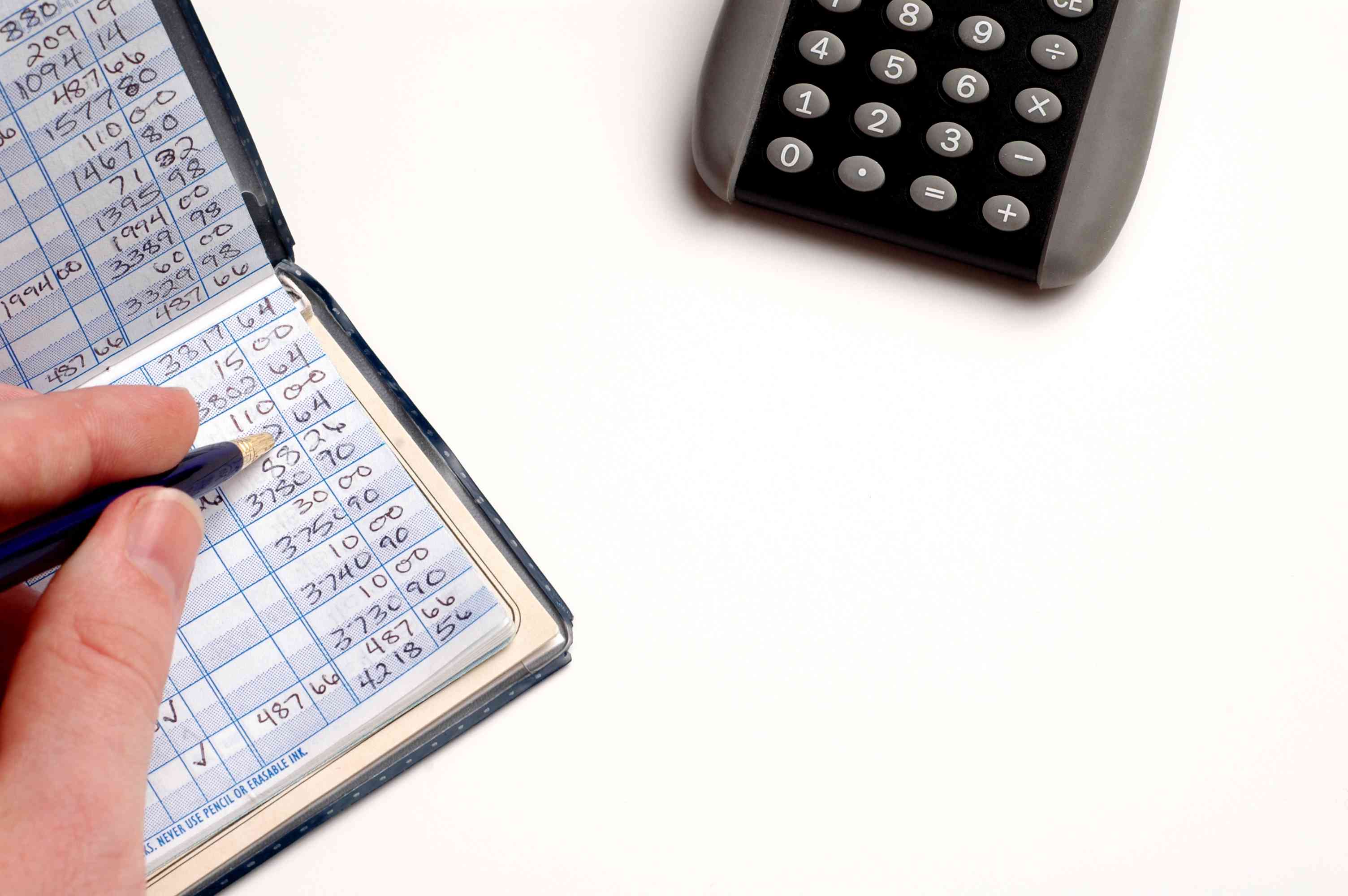 Hand Balancing a Checkbook with Pen and Calculator