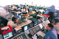 Traders sitting at terminals in a large room