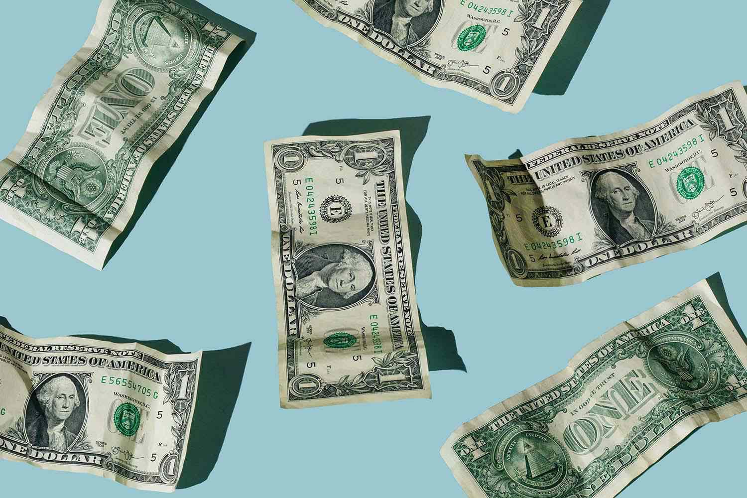 Crumpled one dollar bills on blue background