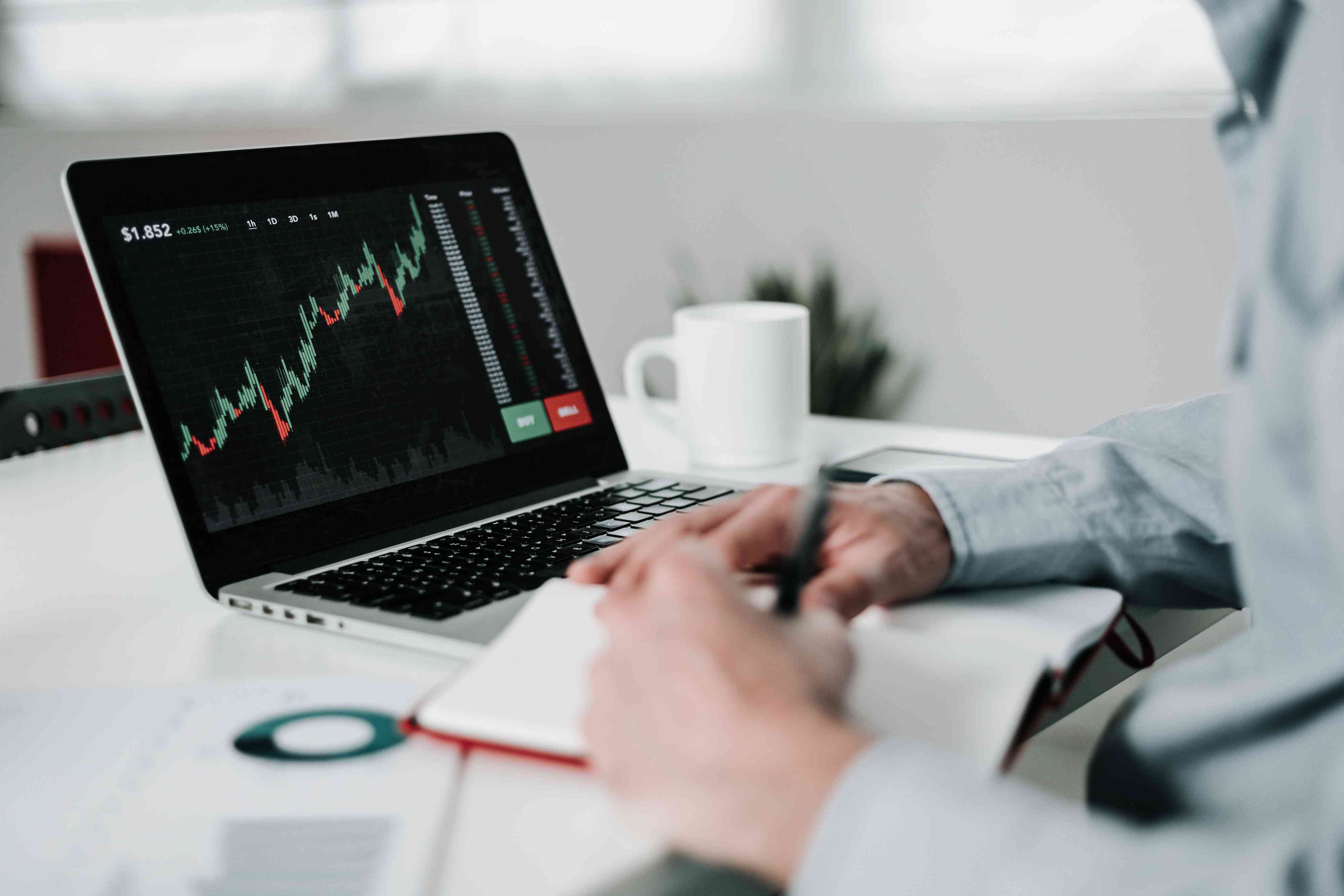 Young businessman using laptop for analyzing cryptocurrencies
