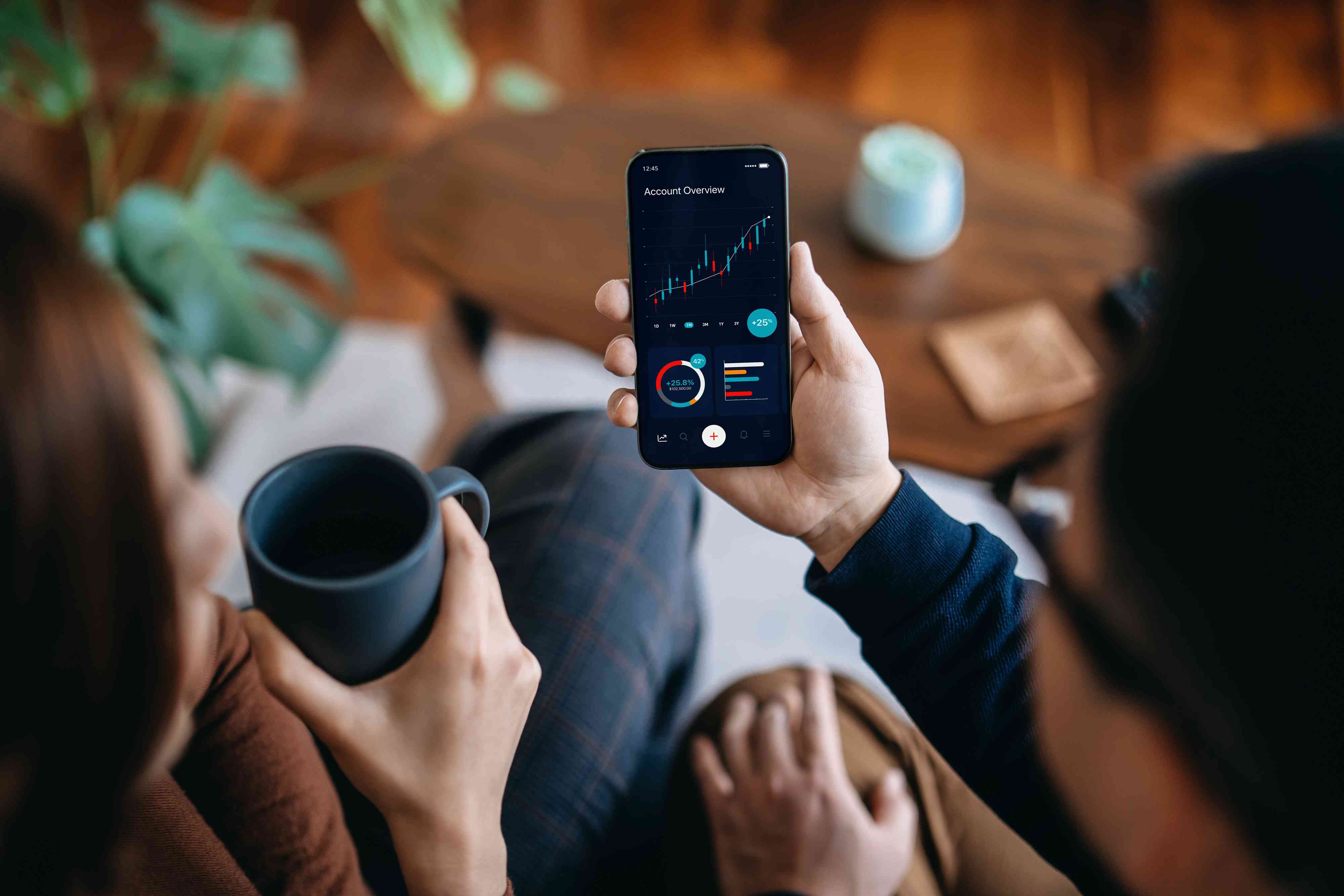 couple managing finance and investment online, analyzing stock market trades with mobile app on smartphone