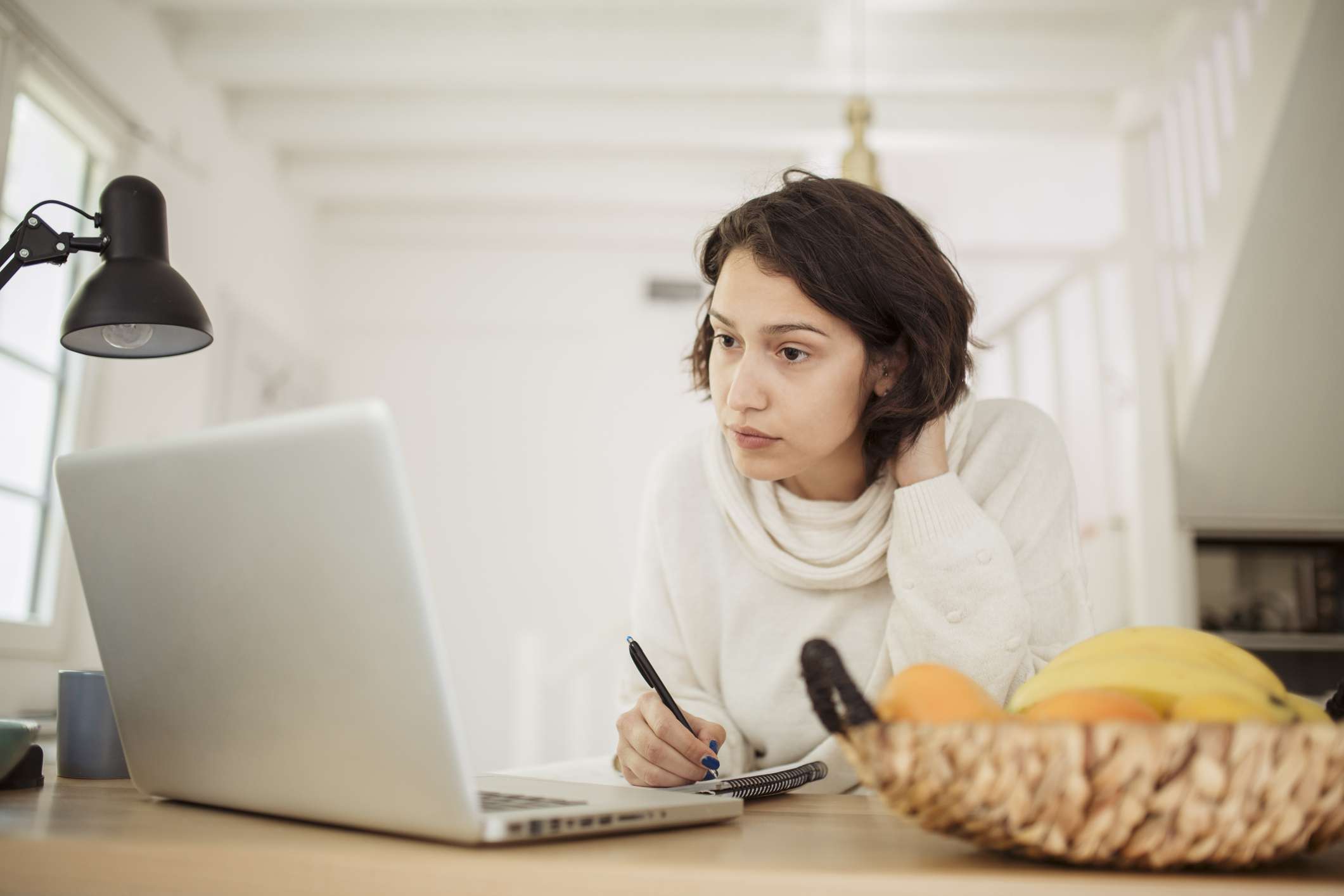 Young adult woman searching for a job online at home